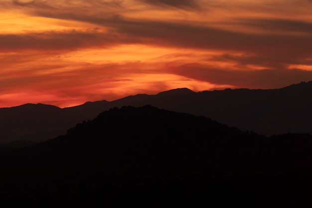 Free Photo dark yellow clouded sky with black mountains