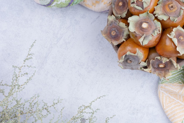 Free Photo date plums in a wooden platter on grey background