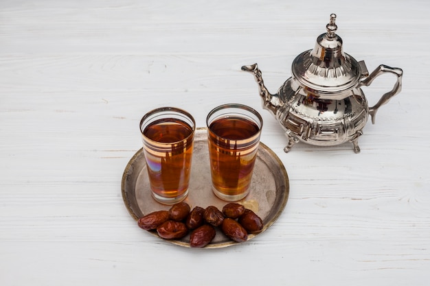 Dates fruit with glasses of tea on table