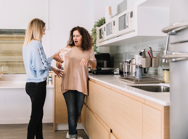 Free Photo daughter giving present to mother in kitchen