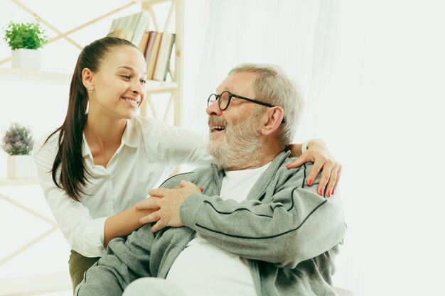 A daughter or granddaughter spends time with the grandfather or senior man