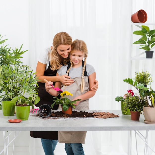 Daughter helping mom in greenhouse