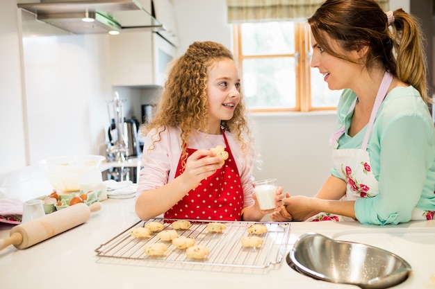 Daughter interacting with mother while having cookies in the kit