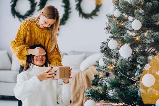 Daughter making present surprise for mother on Christmas