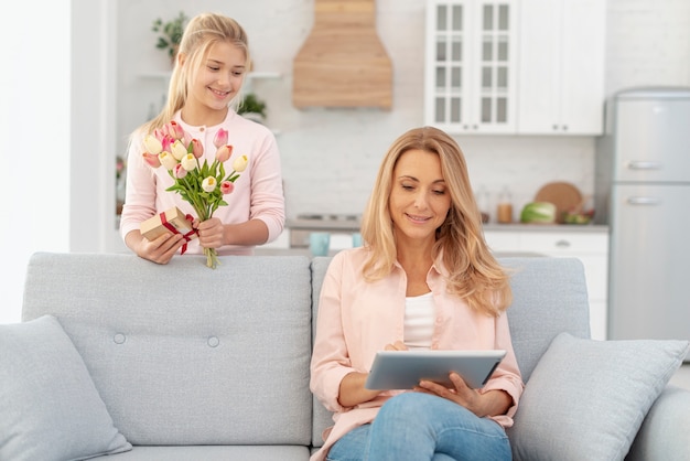 Daughter offering flowers to her mother