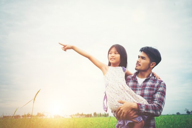 Daughter pointing away and smiling with her dad in the meadows f