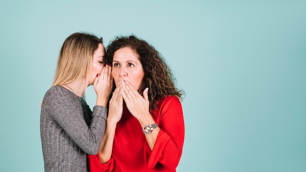 Free photo daughter telling secret to mother