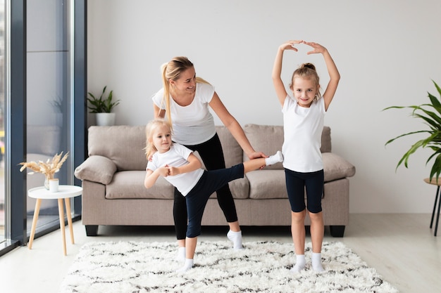 Daughters and mother exercising at home