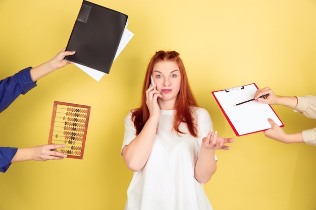 Deadline. Caucasian young woman's portrait on yellow studio