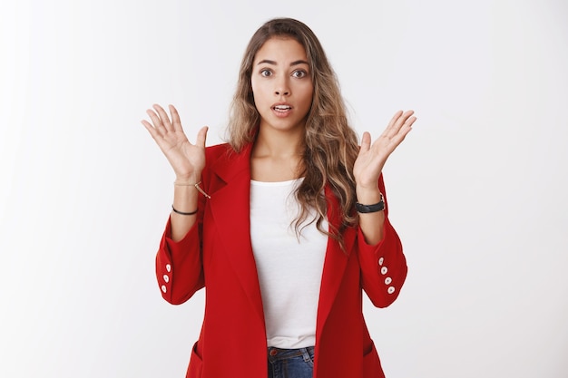 Dear god, what next. Portrait of amazed sympathizing shocked good-looking young european curly-haired woman reacting stunning story raising hands gasping impressed, widen eyes astonished