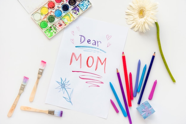 Dear mom inscription on paper with pencils 