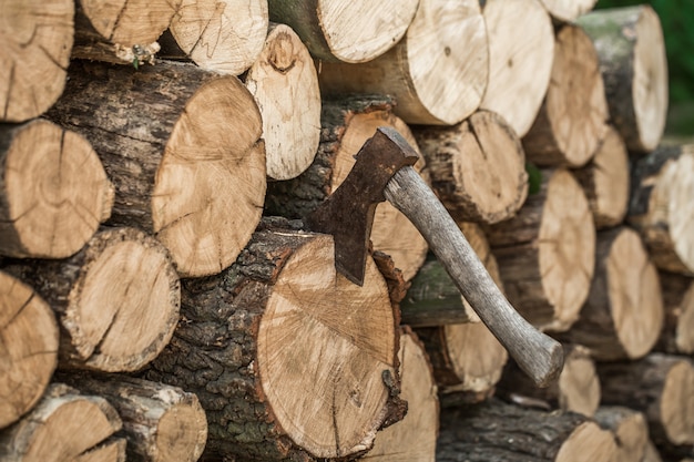 Free photo a deck of stacked logs and an axe