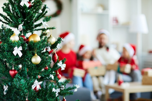 Decorated Christmas tree with blurred family