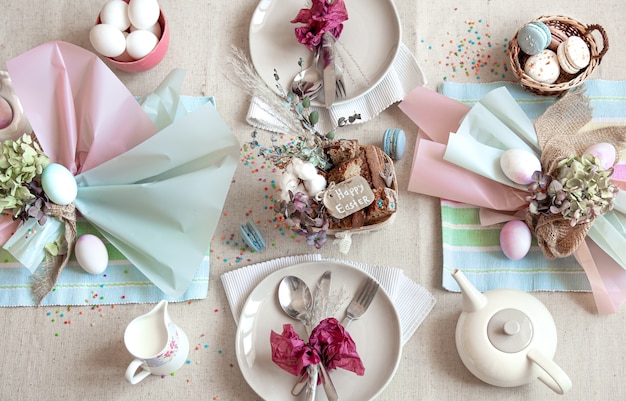 Decorated festive table with Easter dessert, tea and eggs flat lay. Happy Easter concept.