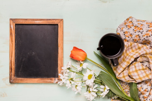 Free photo decorated frame blackboard with flowers and cup