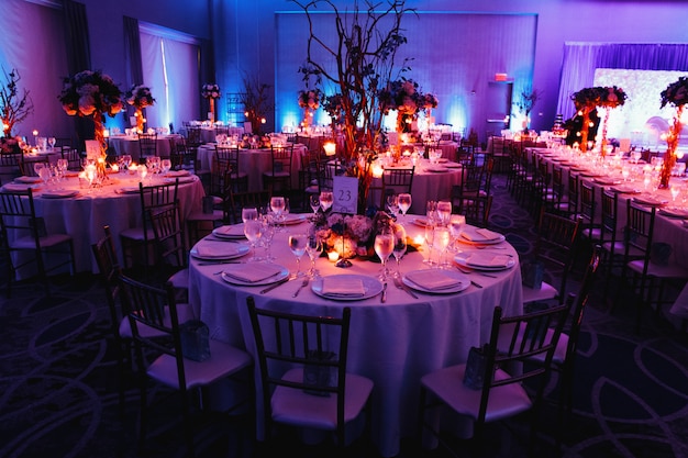 Decorated wedding hall with candles, round tables and centerpieces