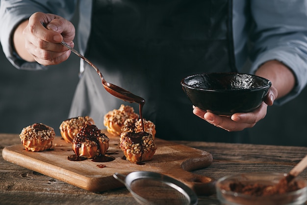 Free photo decorating delicious homemade eclairs with chocolate and peanuts