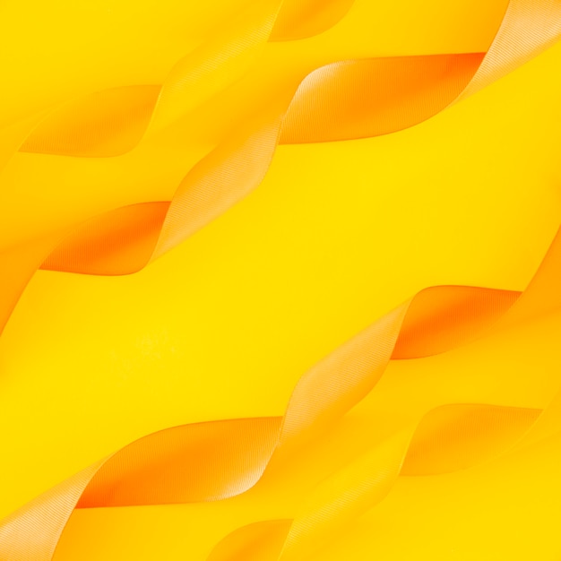 Decoration of curled ribbons on yellow backdrop