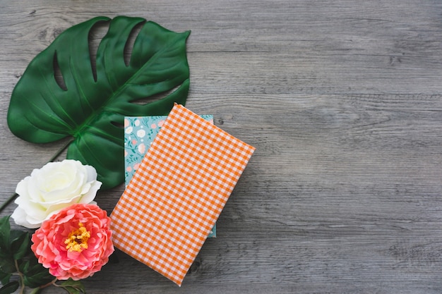 Decorative background with flowers, books and palm leaf