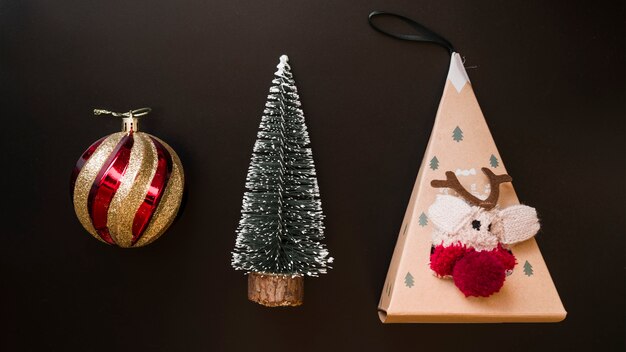 Decorative ball near Christmas toy and fir tree