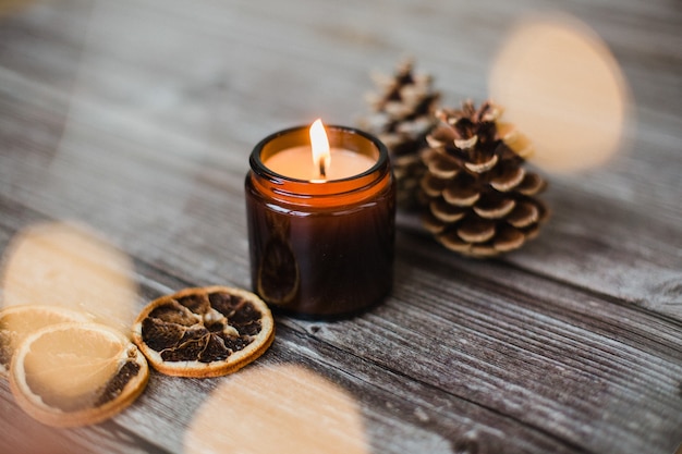 Free photo decorative candle, dried orange slices and pine cones