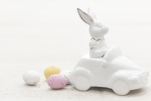 Free Photo decorative ceramic hare in a car and easter eggs closeup