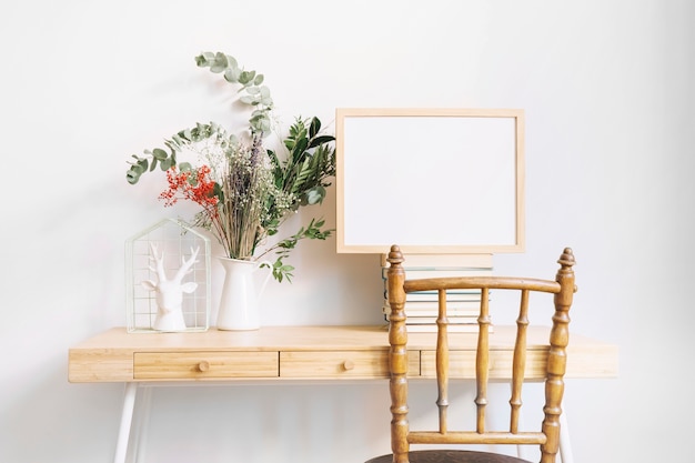 Free photo decorative desk with frame next to plant