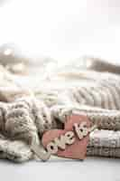 Free photo a decorative heart among cozy knitted items valentines day holiday concept