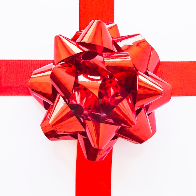 Free Photo decorative red satin ribbon on white backdrop