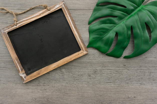 Free photo decorative slate next to a green leaf