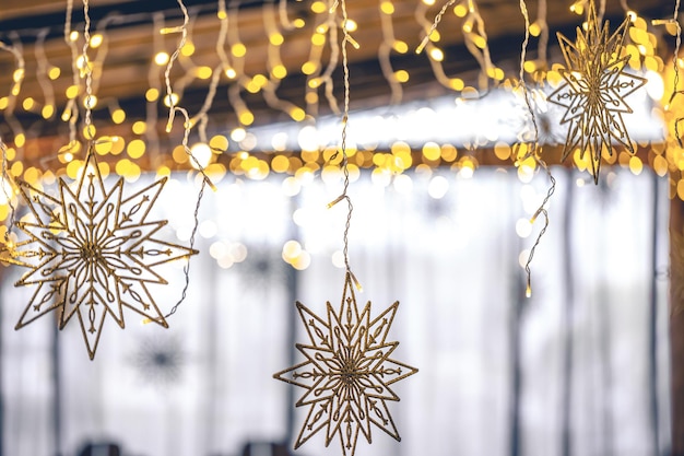 Decorative snowflakes and garlands on a blurred interior background