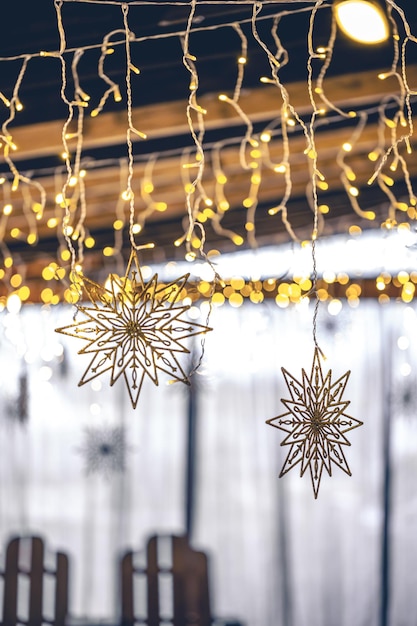 Decorative snowflakes and garlands on a blurred interior background