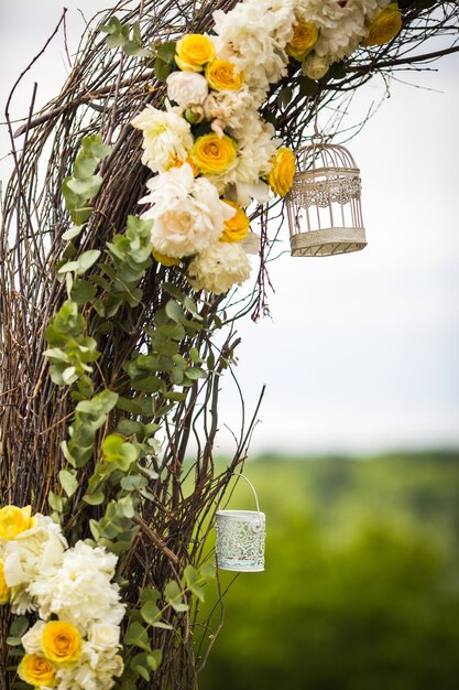 Decorative white bird cages hang on osier wedding altar 