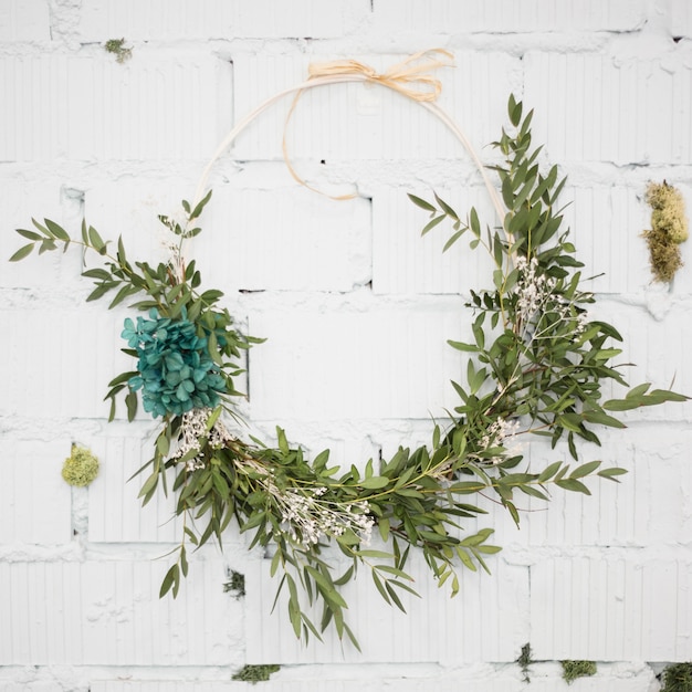 Free Photo decorative wreath attached on white brick wall