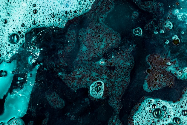 Free photo deep blue liquid with spume and black blobs