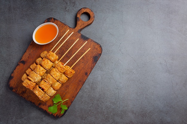 Deep fried fhicken roll on the dark surface.