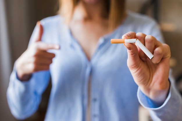 Defocus woman pointing at broken cigarette