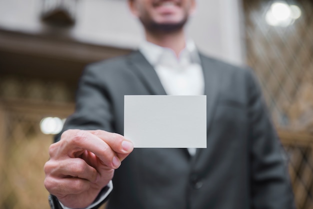 Free Photo defocused businessman showing white visiting card