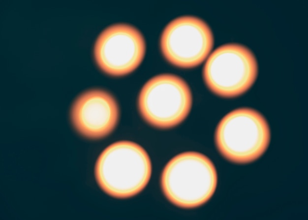 Free photo defocused illuminated candles on dark backdrop