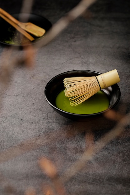 Free Photo defocused matcha tea in bowl with bamboo whisk