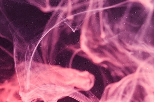 Defocused violet smoke on black screen