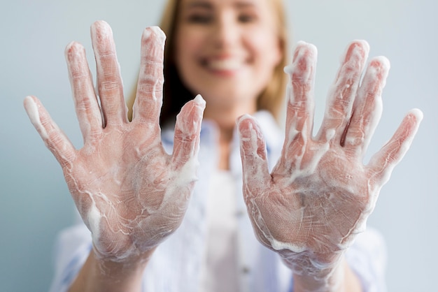 Free photo defocused woman showing her hands covered in soap