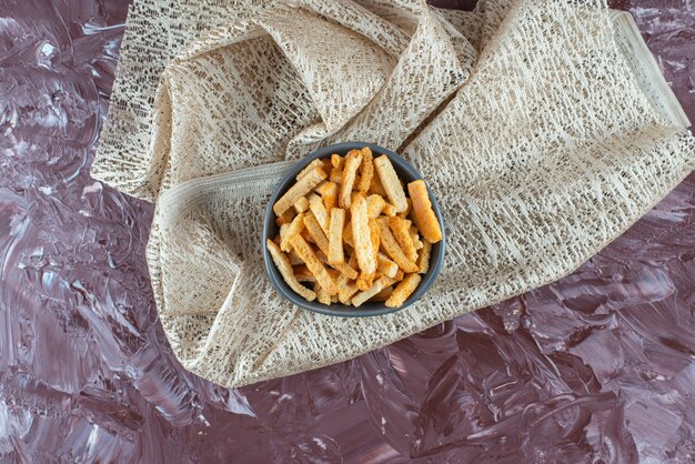 Delectable crispy breadcrumbs in a bowl on a tablecloth, on the marble table. 