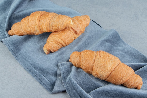 Free photo delectable croissant on towel , on the marble background. high quality photo