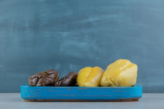 Free photo delectable pickles eggplants and sweet peppers on the wooden plate