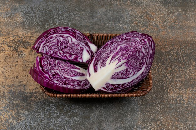 Delectable red cabbage in the wicker basket on the marble surface