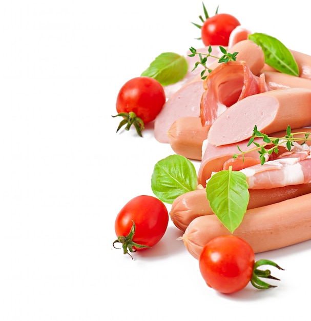 Free photo delicate meats (sausage and ham) decorated with basil and tomatoes isolated