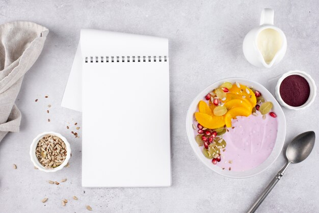 Delicious açai bowl arrangement with empty notepad