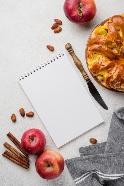 Delicious apple pie with notepad flat lay