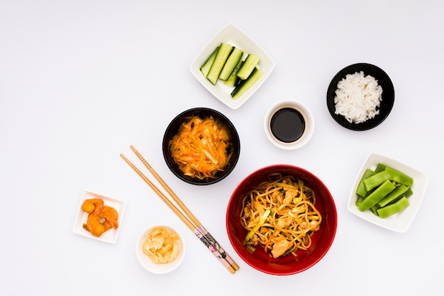 Delicious asian food with ingredients arranged on white backdrop